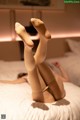 A woman laying on a bed with her legs up in the air.
