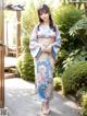 A woman in a blue and pink kimono posing for a picture.