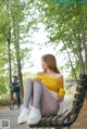 A woman sitting on a bench in a park.