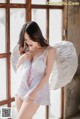 A woman in a white lingerie with angel wings.