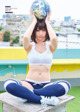 A woman sitting on top of a wooden bench holding a globe.