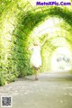 A woman in a white dress is running through a tunnel.