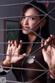 A woman in a police uniform is behind bars.