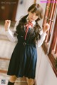 A woman in a school uniform holding a stick.