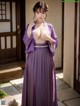 A woman in a purple kimono posing for the camera.