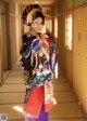 A woman in a kimono standing in a hallway.